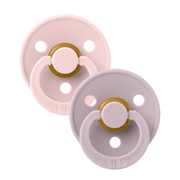 Two BIBS round pacifiers shown together, featuring soft pink and muted lavender shields with ventilation holes