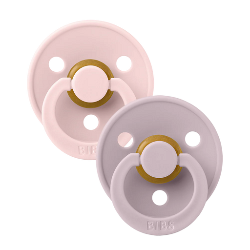 Two BIBS round pacifiers shown together, featuring soft pink and muted lavender shields with ventilation holes