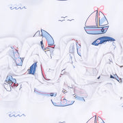 a ruffled edge, featuring a nautical sailboat pattern in shades of blue, pink, and red.