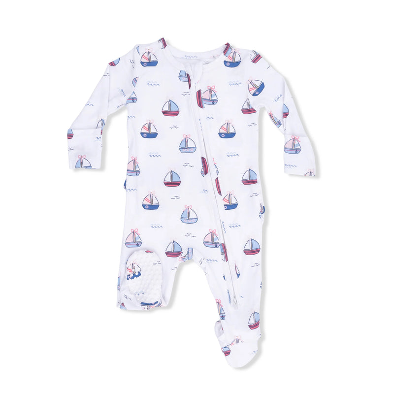 A baby long-sleeve footed sleeper in white, featuring an all-over print of small sailboats in red, blue, and pink, with a zip front and a soft pocket on one leg.