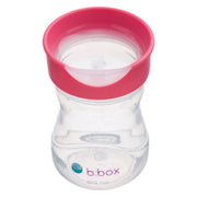 Clear b.box sippy cup with pink lid on a white background