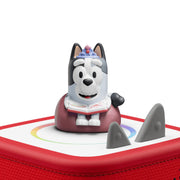 Toy figure of a dog on a red and white base with a white background