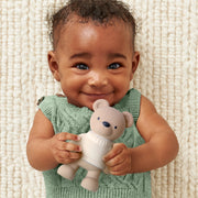 Baby holding and chewing on the teething bear