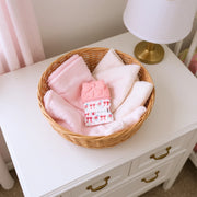 Teether mitt displayed in a small basket on a nursery table