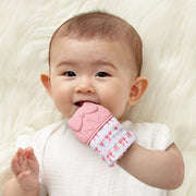 Baby wearing and chewing on the Itzy Ritzy silicone teether mitt during teething