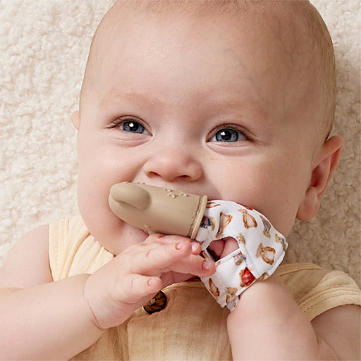 Baby wearing and chewing on the Itzy Ritzy teether mitt during teething