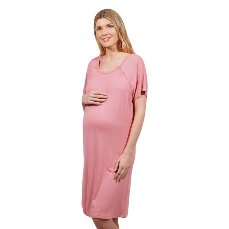 A pregnant woman wearing a pink short-sleeve maternity nightshirt, standing against a plain white background.