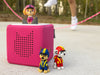 Skye Tonie on a pink Toniebox outdoors with additional PAW Patrol figures, lifestyle scene