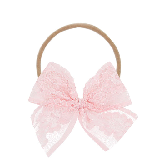 Pink lace bow hair accessory on a white background