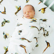 Newborn wrapped in Saltwater Swaddles Pheasant and Quail blanket showing detailed pheasant and quail illustrations