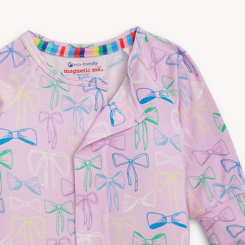 Pink children's onesie with colorful bow pattern on a white background