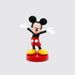 A figurine of Mickey Mouse standing with one hand extended, wearing a black and white outfit on a red base.