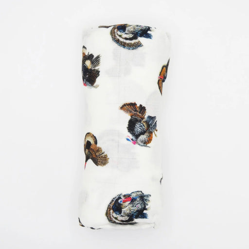 baby blanket featuring a scattered print of wild turkeys in black, brown, and blue, with a small red comb detail, shown on a plain white background.