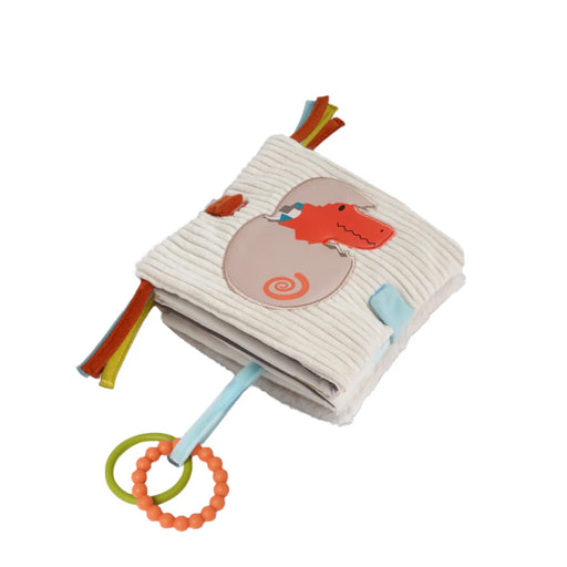 Soft cream-colored plush dino activity book with a baby T-rex hatching on the cover and colorful ribbon tags.