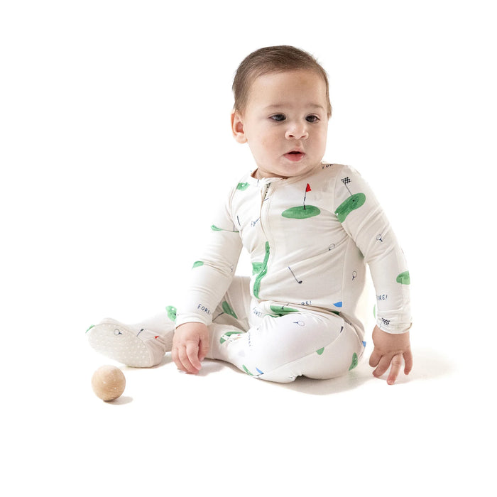 Baby sitting on the floor wearing the All Fore Golf footie.