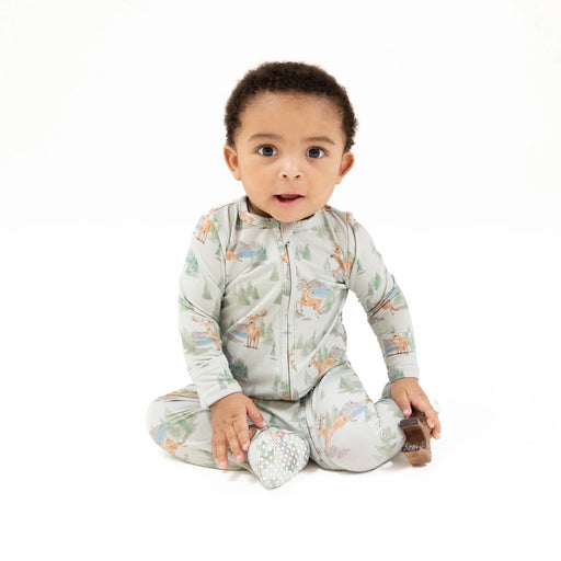 Baby wearing the Buck Deer 2-way zipper footie sitting and smiling