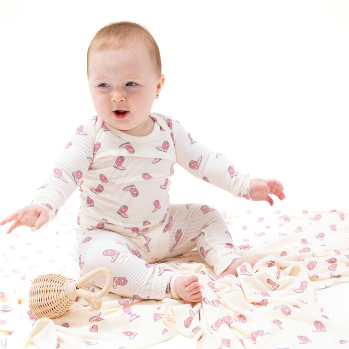 Baby wearing cowgirl boots loungewear set, sitting and smiling