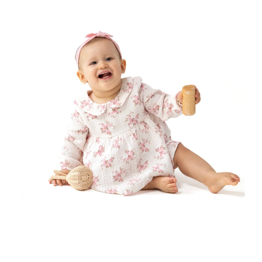 Baby wearing the Belle Rosette Dot smocked bubble with tutu, smiling while sitting