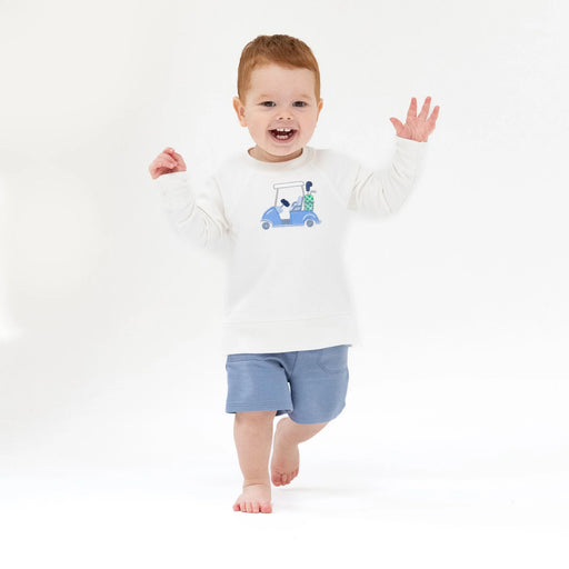 Toddler wearing white golf cart raglan sweatshirt, walking and smiling