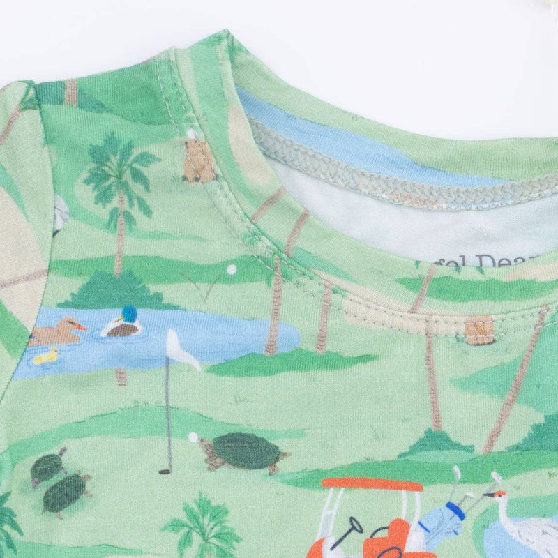 Close-up of a fabric with a golf course pattern featuring trees, water, and golf equipment.