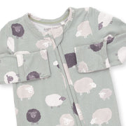 A long-sleeve baby sleep sack in sage green with a pattern of sheep in white, light pink, and dark purple, featuring a front zipper and pocket details.