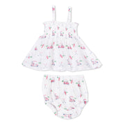 A baby girl's two-piece outfit set consisting of a white smocked dress with thin shoulder straps and matching white smocked bloomers, both decorated with a colorful pink, green, and blue golf-themed print, shown against a plain white background.