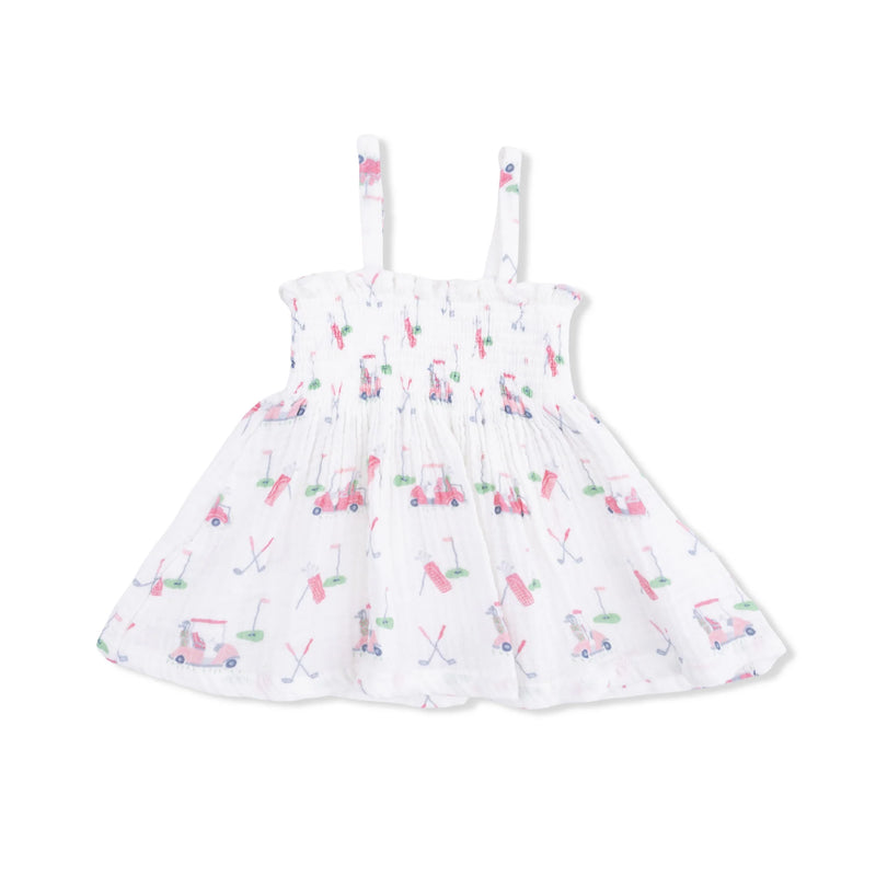 A white sleeveless baby dress with thin shoulder straps, featuring an allover print of pink and blue golf carts and golf clubs on a clean white background.