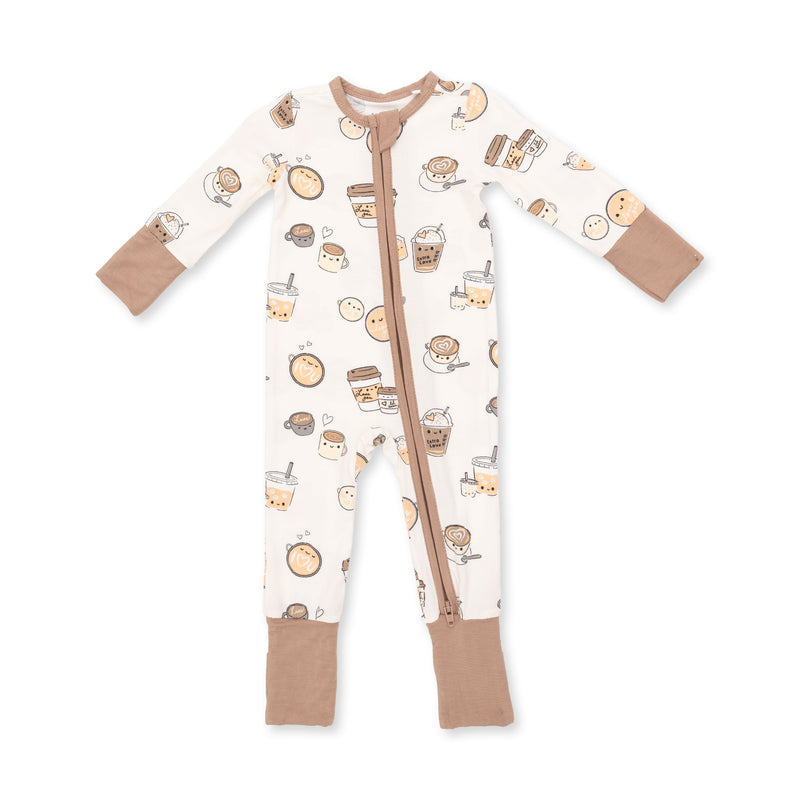 A baby long-sleeve footless one-piece sleeper with a front zipper, featuring a cream background with a cute cartoon bubble tea and pastry pattern, and solid tan cuffs and foot covers.