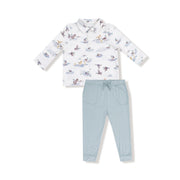 Children's outfit with a duck patterned long-sleeve shirt and light blue pants on a white background