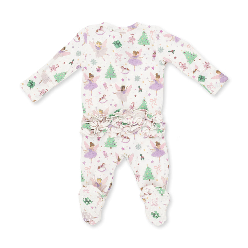 A baby footed one-piece sleeper with long sleeves and a ruffled waist, featuring a whimsical print of fairies, Christmas trees, and snowflakes on a white background.