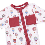 A baby long-sleeve sleep sack with a white background printed with colorful hot air balloon motifs, featuring solid red trim, a red front zipper, and two red patch pockets on the sleeves.