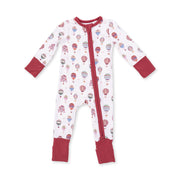 A baby long-sleeve footed sleeper with a white background, decorated with a colorful hot air balloon pattern, featuring solid red cuffs, collar, and zipper trim.