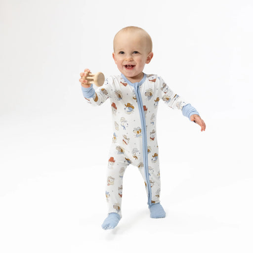 Baby wearing a cowboy dog patterned onesie on a white background