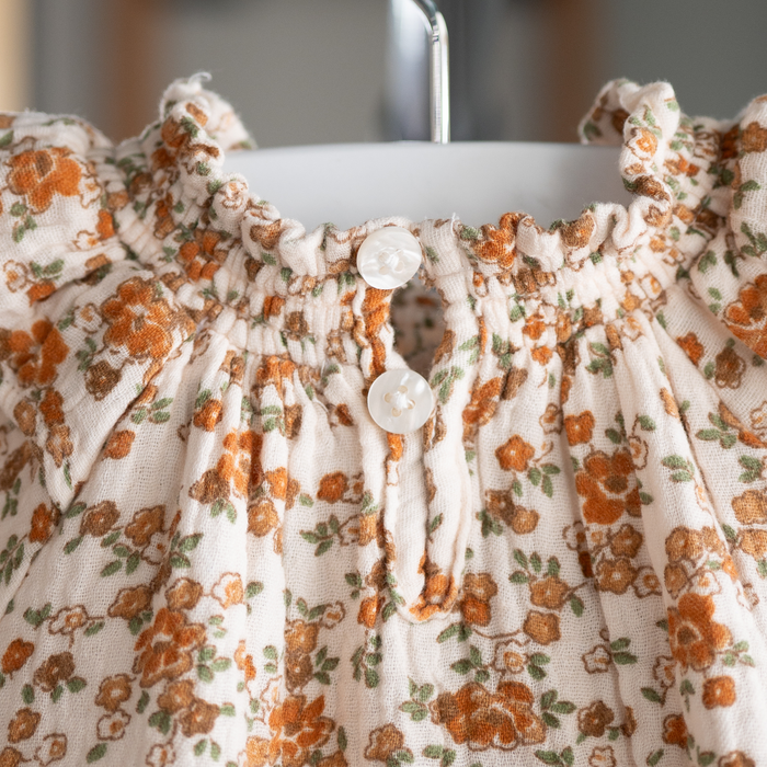 Floral dress with orange flowers on a hanger
