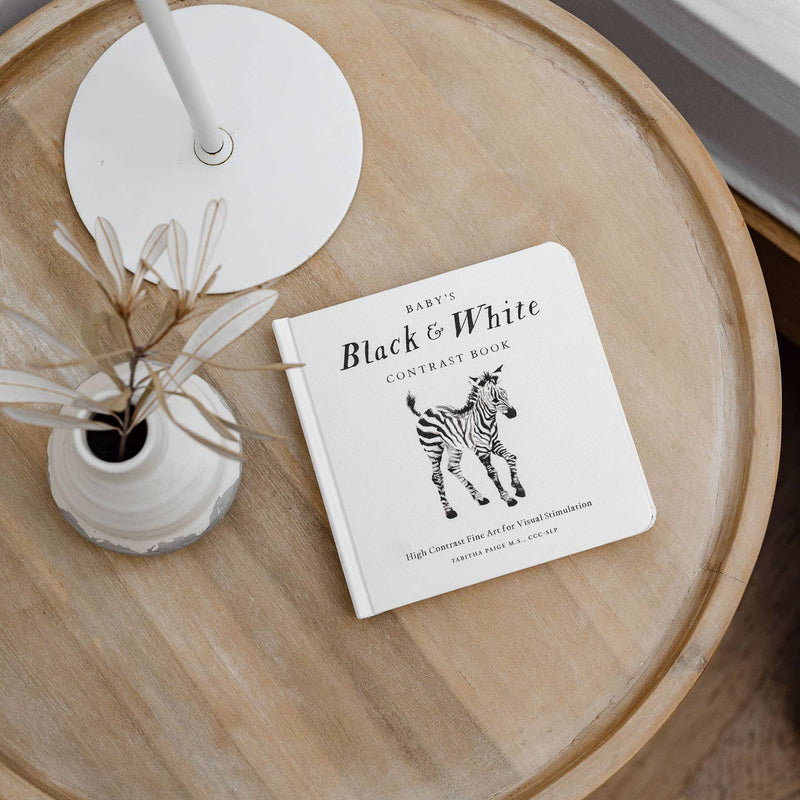 Round wooden table with a zebra-themed book on a white surface