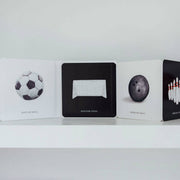 Collection of card decks with sports-themed designs on a white shelf.