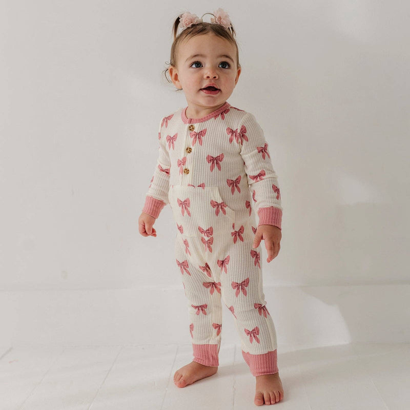Toddler standing in the babysprouts Rose Elegance Bows waffle romper
