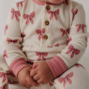 Close-up of the waffle texture and snap buttons on the babysprouts Rose Elegance Bows romper