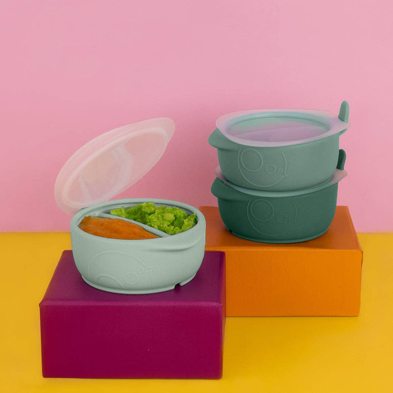 Green baby food containers with food on a colorful background