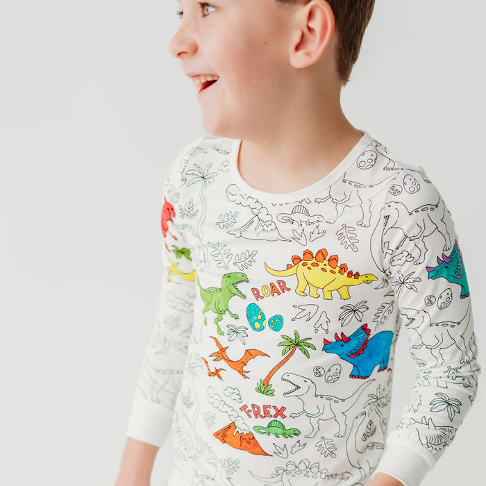 Young child wearing dinosaur-themed colorable pajamas with partial colored designs