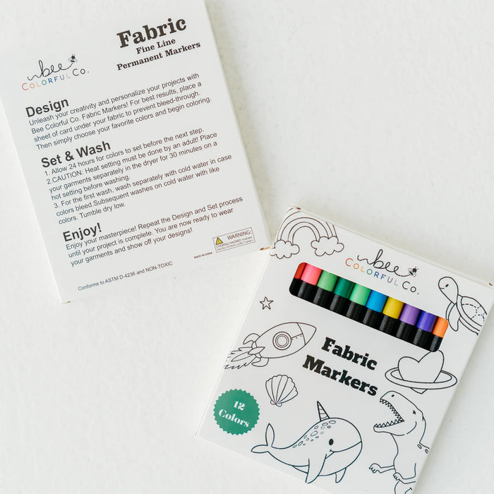 Fabric markers and instruction card displayed beside colorable pajama fabric