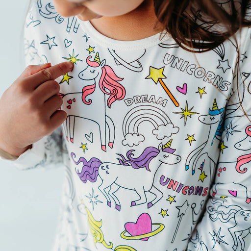 Close-up of child wearing unicorn-themed colorable pajamas with partially colored designs