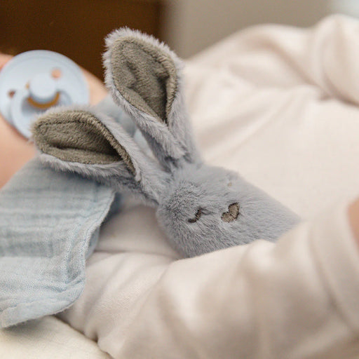 Baby holding and playing with the BIBS kangaroo rattle during quiet playtime