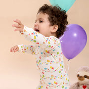 Toddler in Birthday Babe RightFit pajamas reaching during birthday-themed play