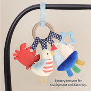 Bitzy Busy Ring attached to a car seat handle with multiple dangling sensory toys