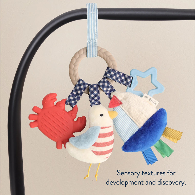Bitzy Busy Ring attached to a car seat handle with multiple dangling sensory toys