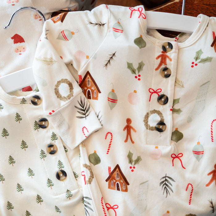 Baby clothes with Christmas-themed patterns on a white background