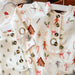 Baby clothes with Christmas-themed patterns on a white background