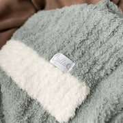 Closeup of sage Alani blanket showing ribbed texture and cream border