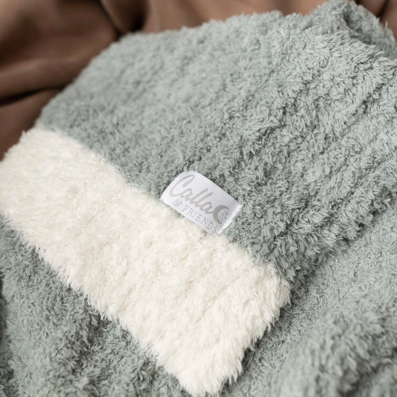 Closeup of sage Alani blanket showing ribbed texture and cream border